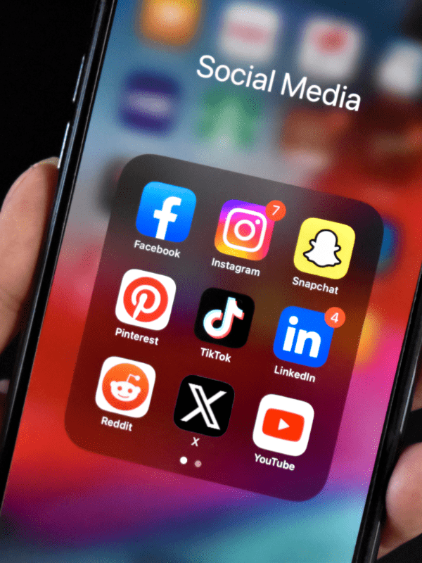 Smartphone in einer Hand mit Social Media Icons